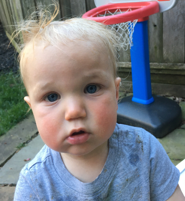 toddler standing in front of a basketball hoop