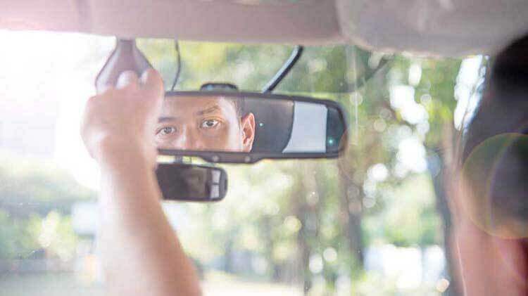 Man looking into rearview window