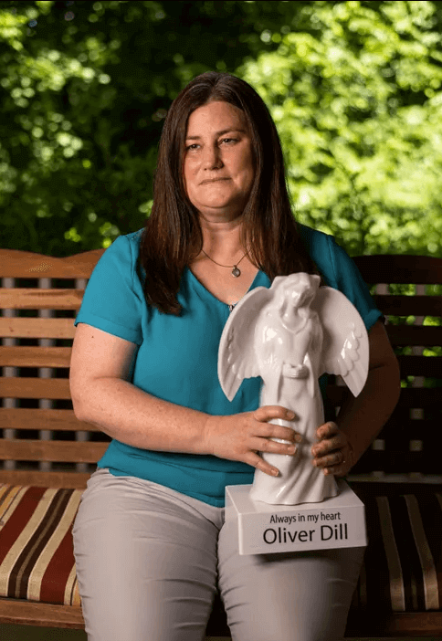 Jamie Dill holds a memorial angel in honor of her son Oliver that sits outside the Dill family home in Evansville, Ind., Wednesday, June 16, 2021. His brother Oliver, also known as "Ollie," died in 2019 after accidentally being forgotten in a car on the University of Southern Indiana campus.