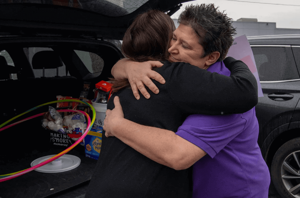 Be Kind for Ollie founder Jamie Dill, left, receives a hug for Center for Pediatric Therapy's Karen Lawson after receiving donations for the non-profits annual benefit dinner in Evansville, Ind.