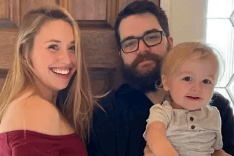 Parents Adam and Chelsey Warren posing with their son Lucas, who died in floodwaters on May 5.